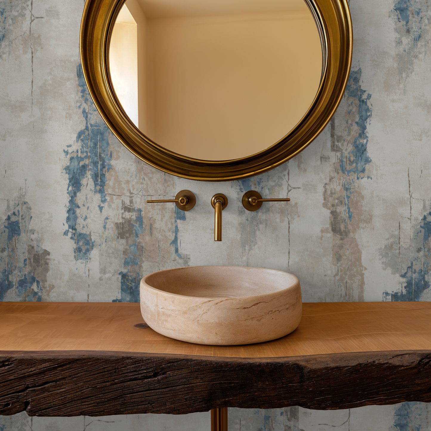 Abstract blue and taupe wallpaper in bathroom with round mirror and stone sink.