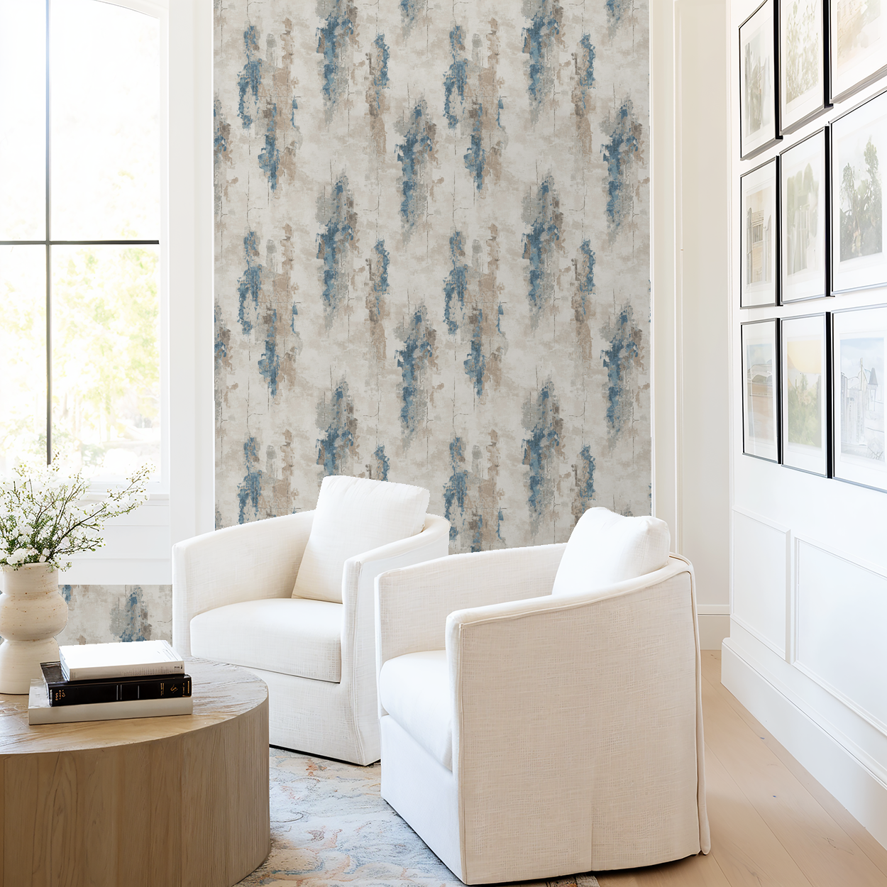 Abstract blue and taupe brushstroke wallpaper in modern living room with white chairs.