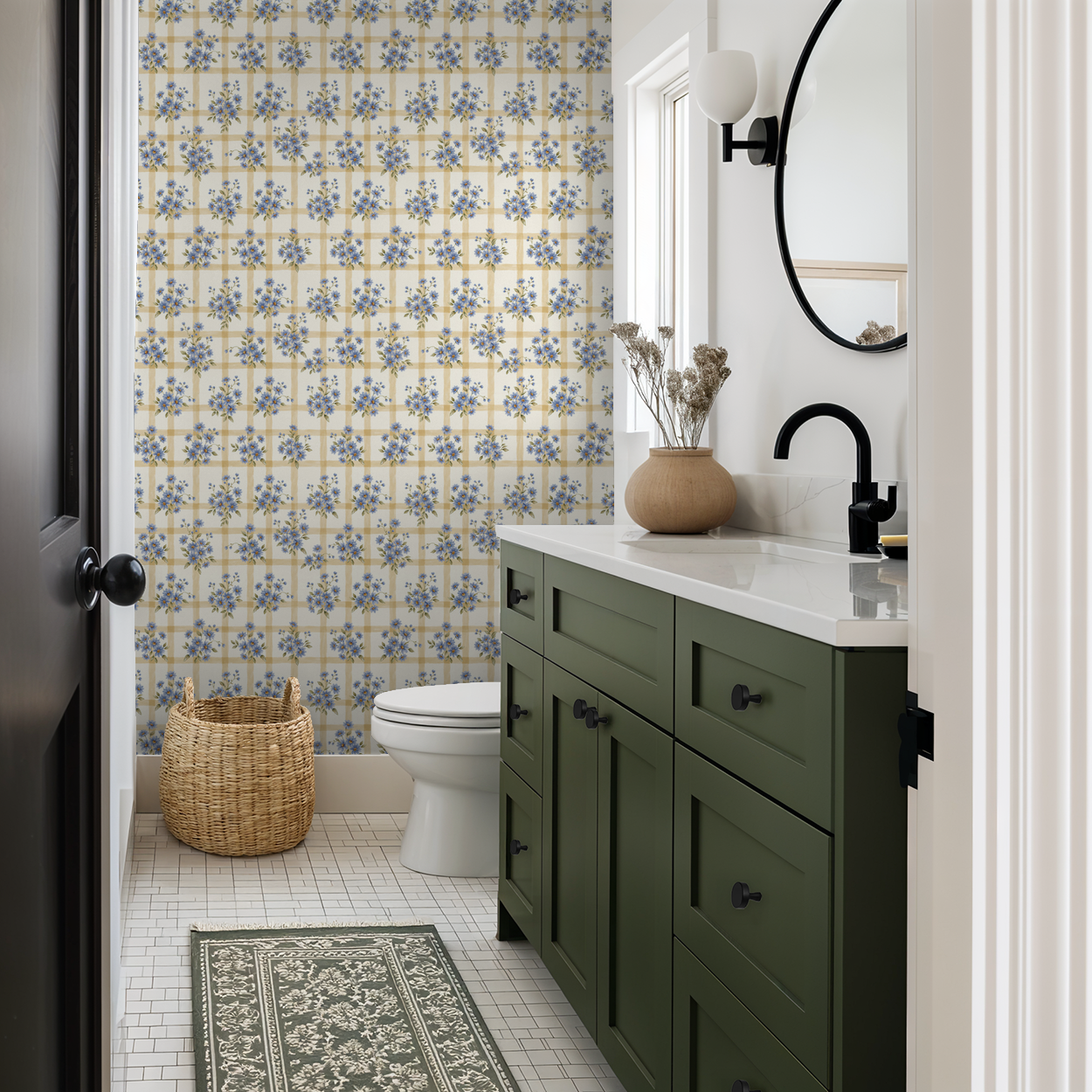 Bathroom with blue floral and gold grid wallpaper, green vanity, and wicker basket.