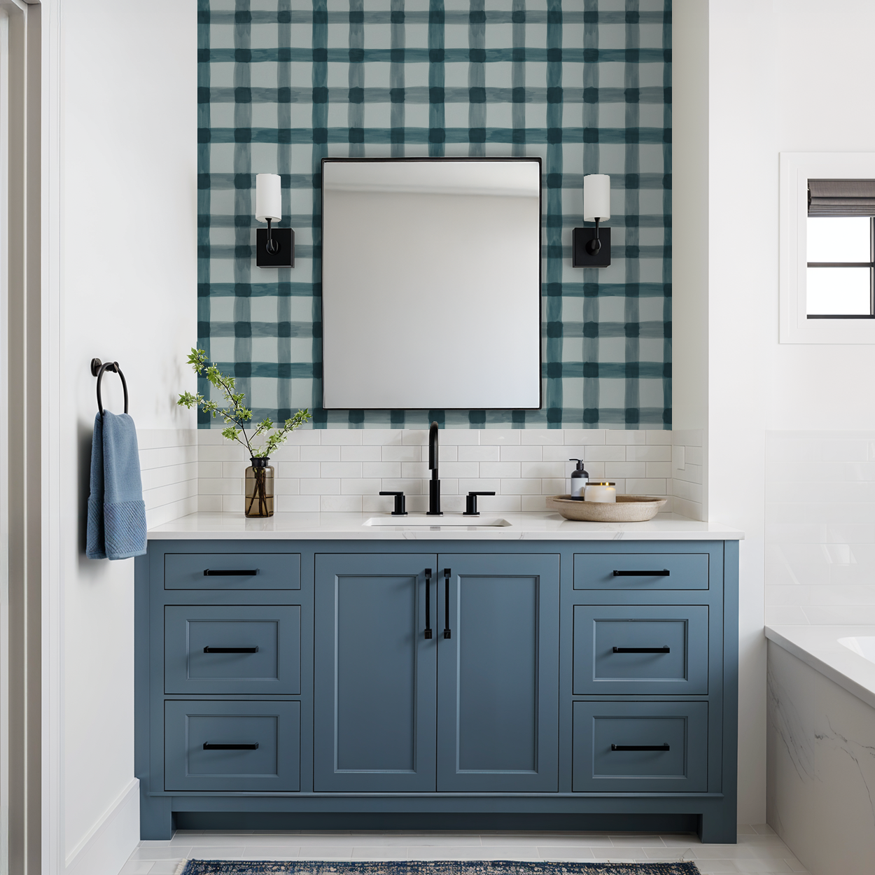 Blue plaid wallpaper in modern bathroom with blue vanity and mirror.