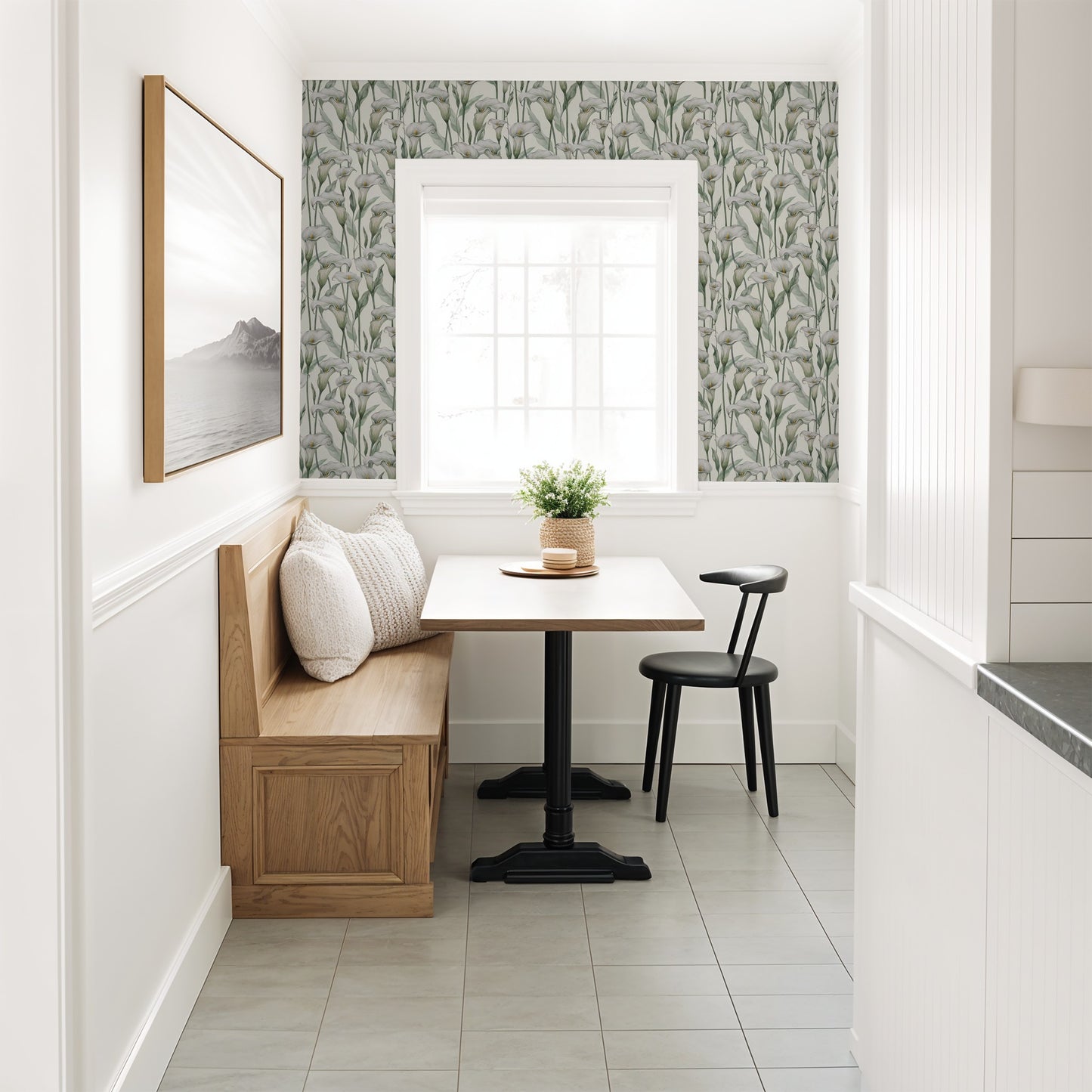 Calla lily floral wallpaper in cozy dining nook with wood bench and black chair.