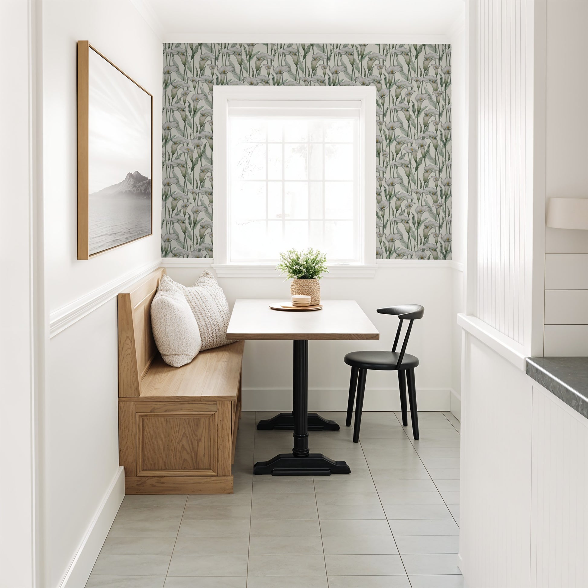 Calla lily floral wallpaper in cozy dining nook with wood bench and black chair.