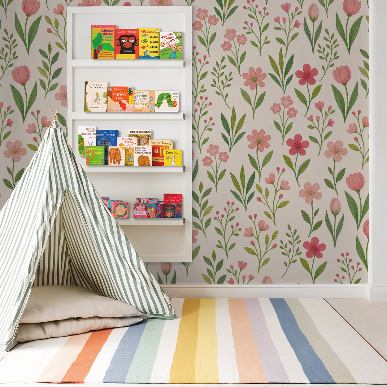 Floral pink tulip wallpaper in a children's playroom with a striped tent and colorful books.