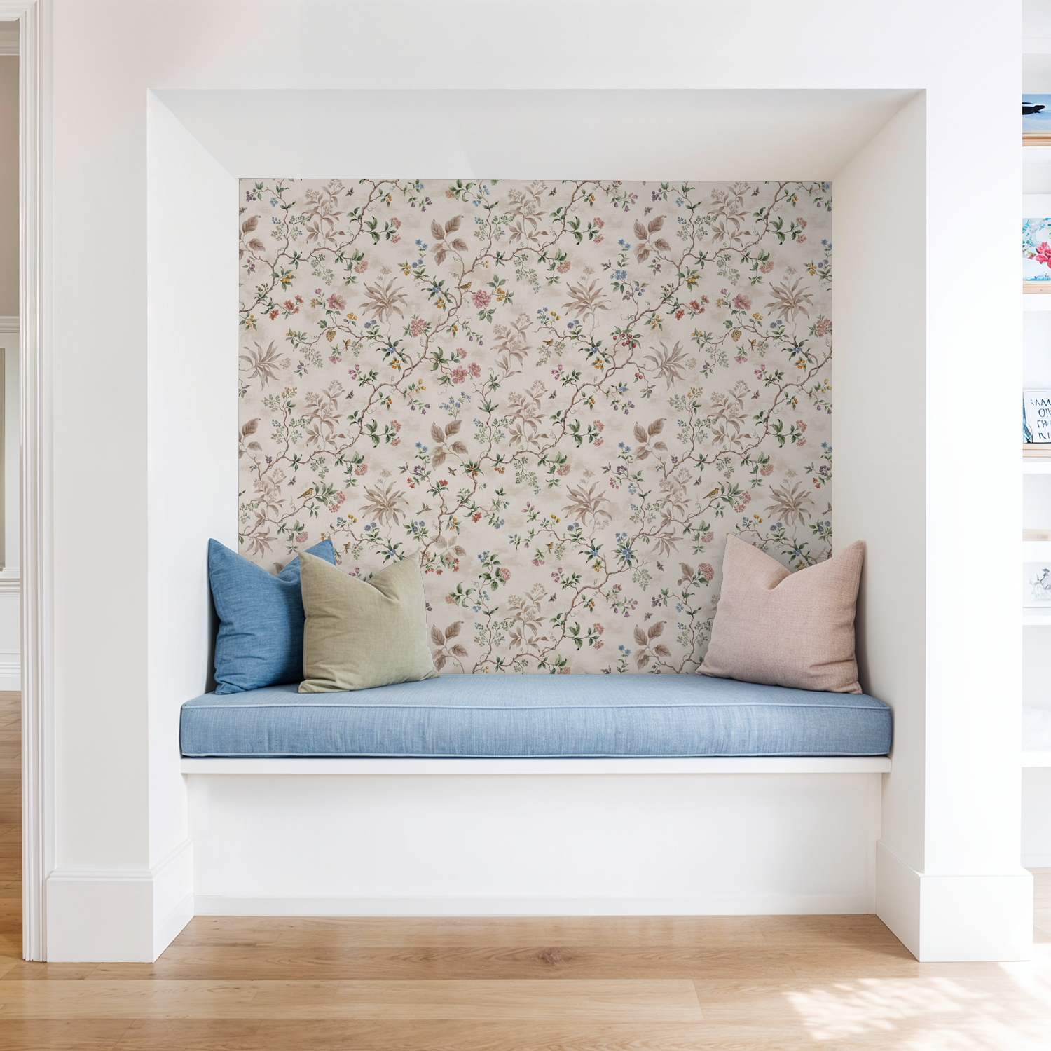 Floral botanical wallpaper with pastel vines in a cozy nook with blue cushions.