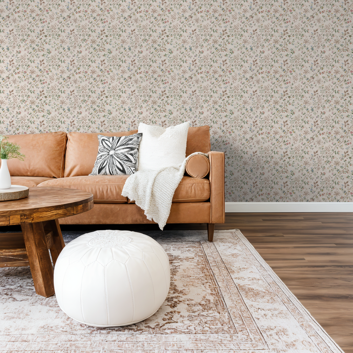 Floral wallpaper with pastel hues in cozy living room with leather sofa.