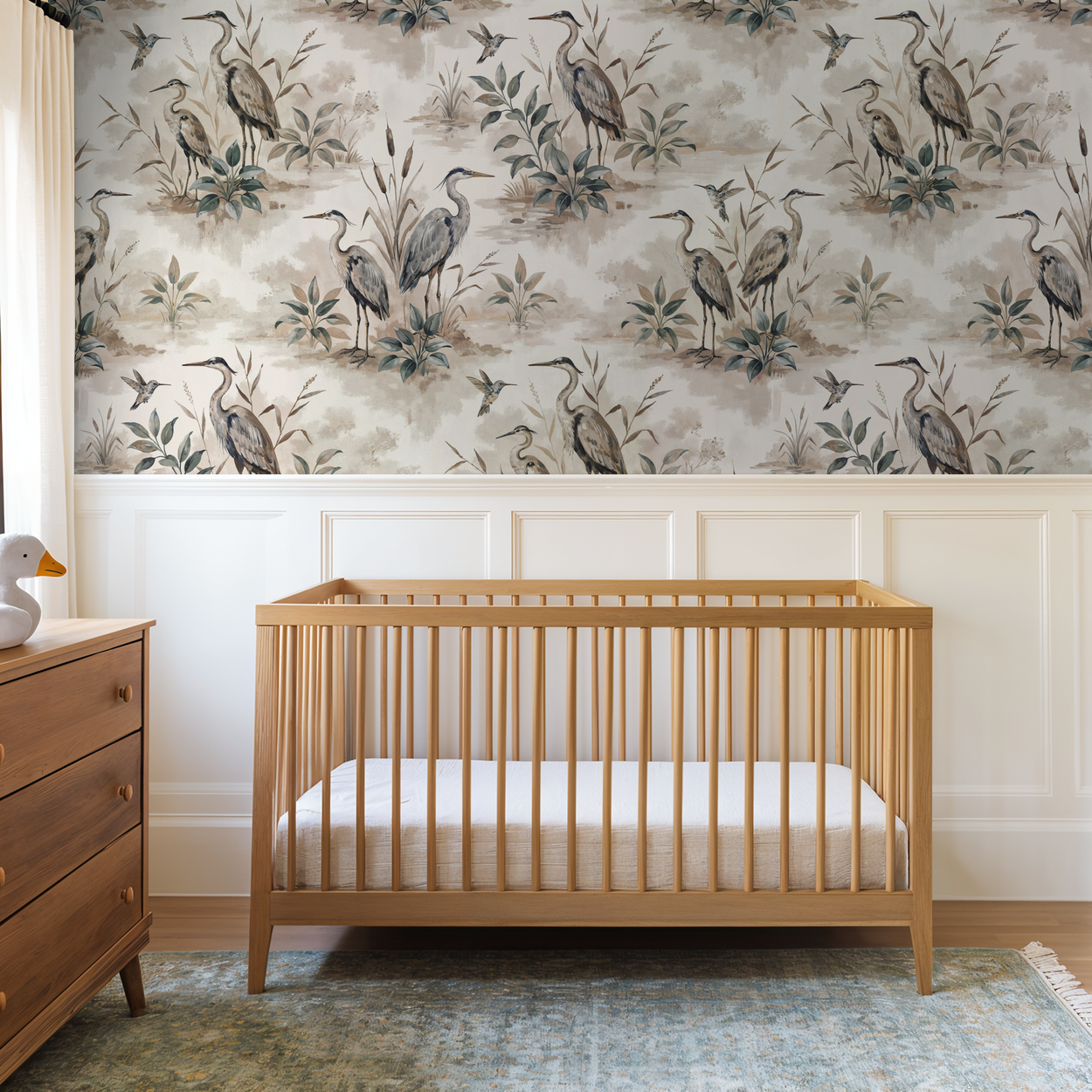 Heron Bay wallpaper with herons and foliage in taupe and sage in a nursery with wooden crib.