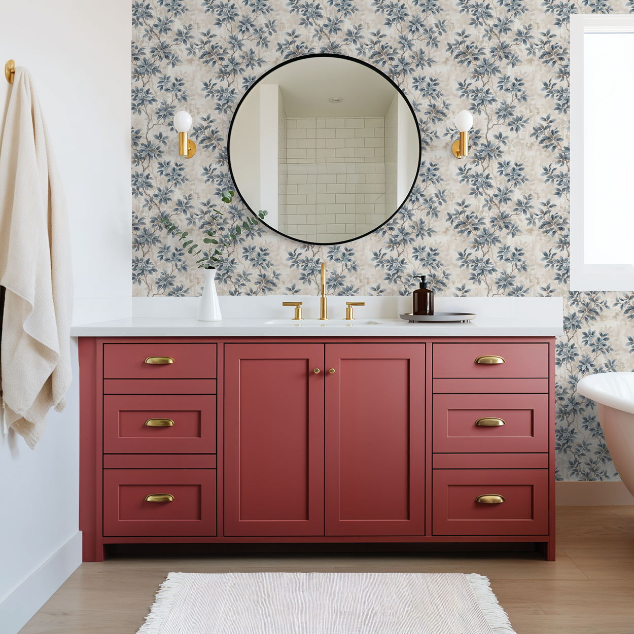 Bathroom with Leafy Daydreams wallpaper in muted blues and greys, red vanity, round mirror.
