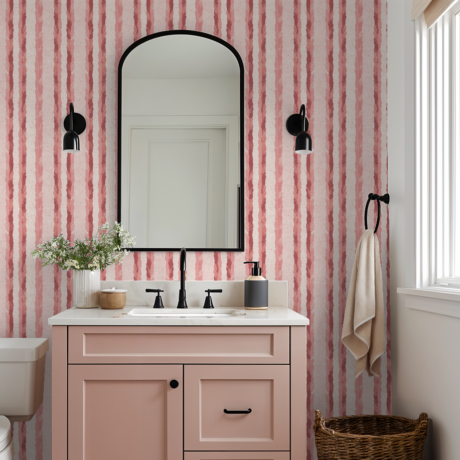 Bathroom with blush and rose striped feather wallpaper and pink vanity.