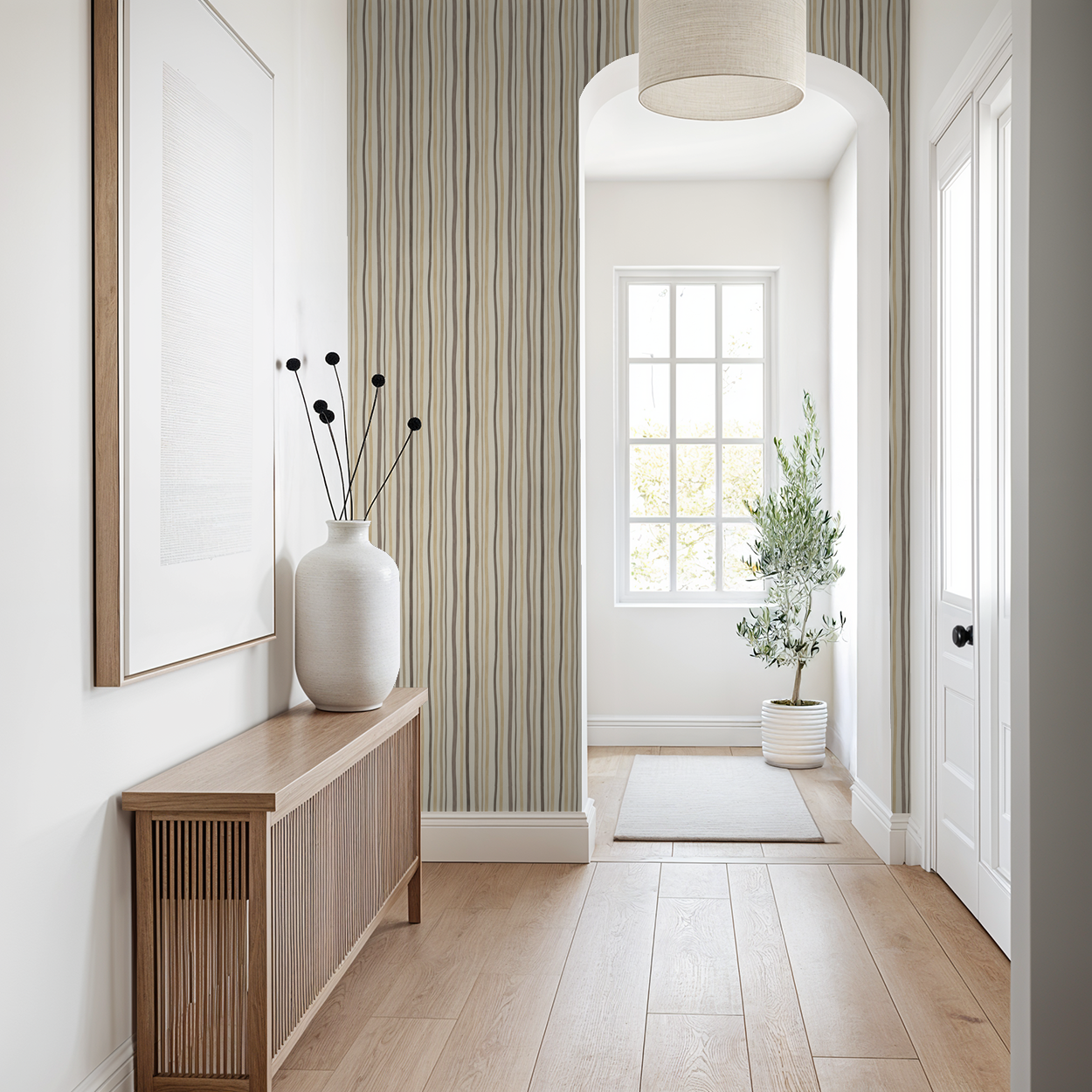 Refined Rhythm wallpaper with vertical lines in beige and taupe in a modern entryway.