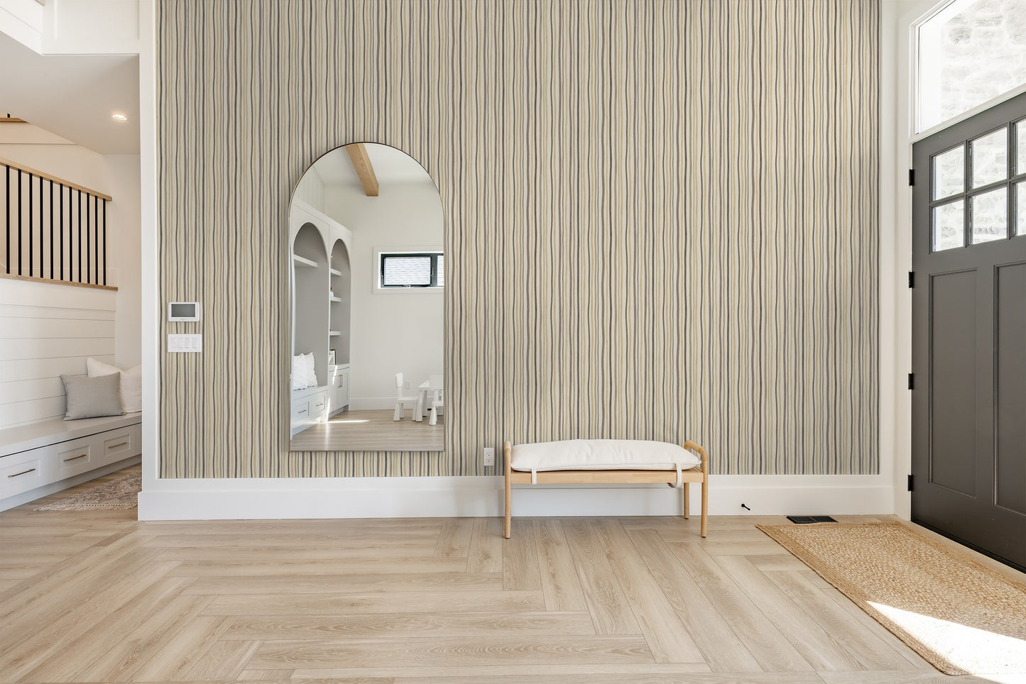 Refined Rhythm wallpaper with flowing vertical lines in beige, taupe, and cream in a modern entryway.