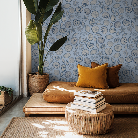 Coastal seashell wallpaper in serene living room with soft blue tones.