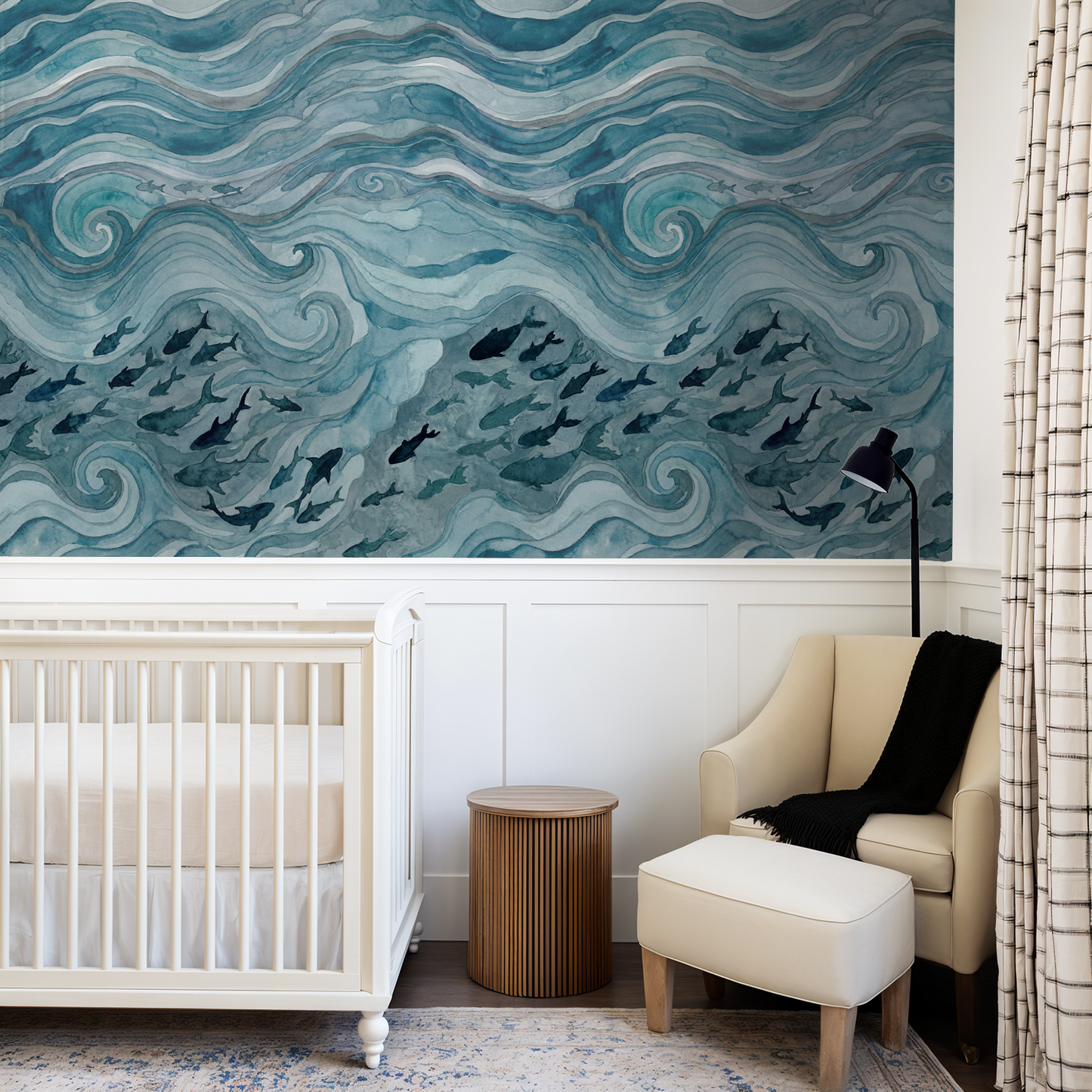 Silent Drift wallpaper with blue waves and fish in a cozy nursery with crib and armchair.