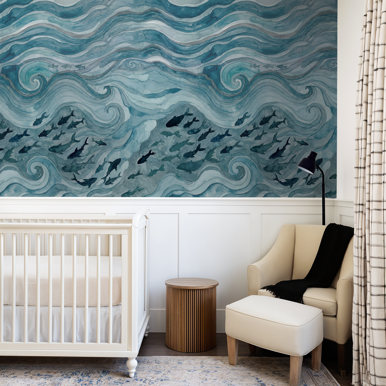Silent Drift wallpaper with blue waves and fish in a cozy nursery with crib and armchair.