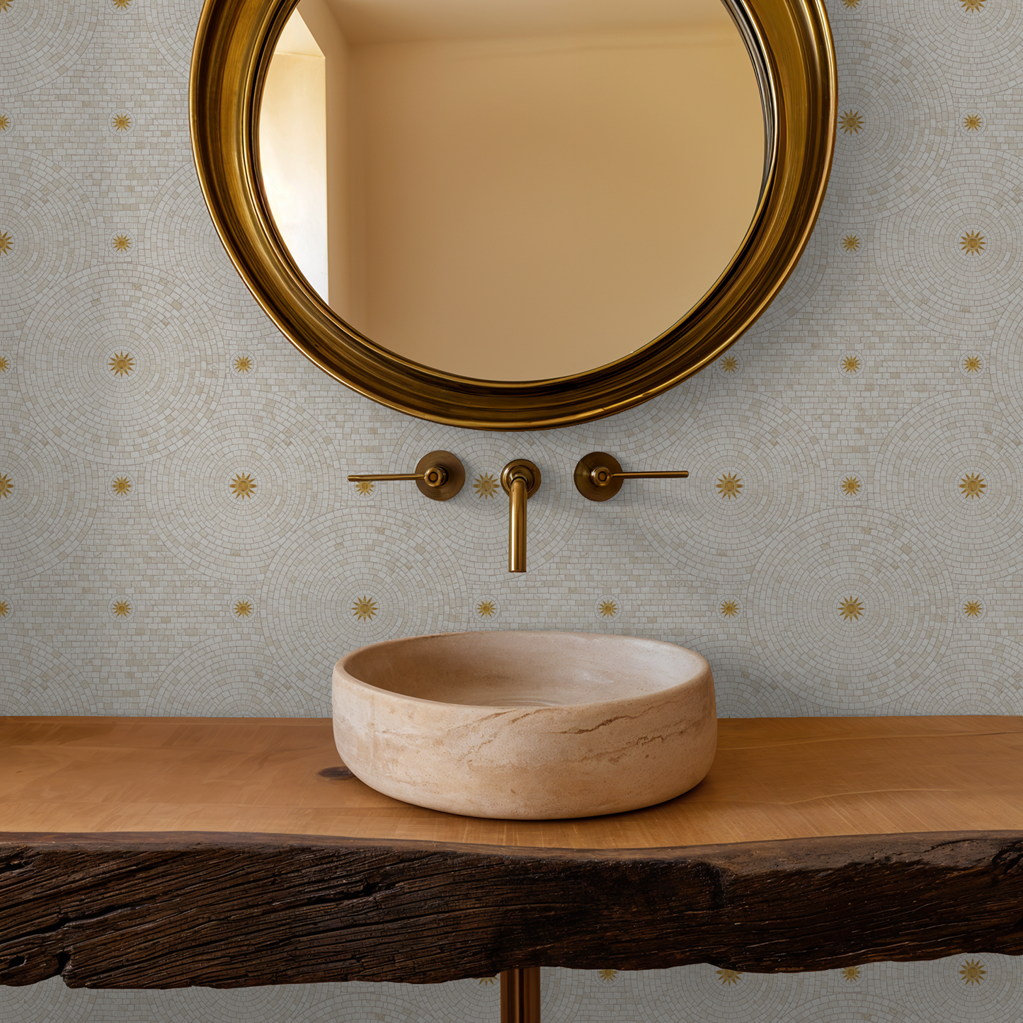 Tiled Sunshine wallpaper with cream and gold mosaic pattern in bathroom setting with round mirror and stone sink.