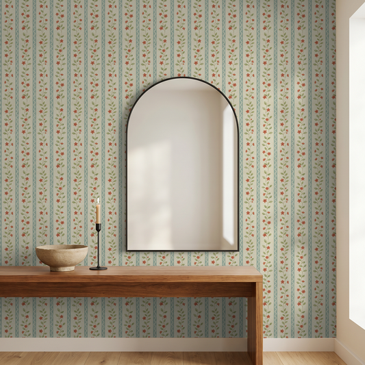 Vintage floral wallpaper with red flowers and vines on cream background in room with mirror and wooden table.