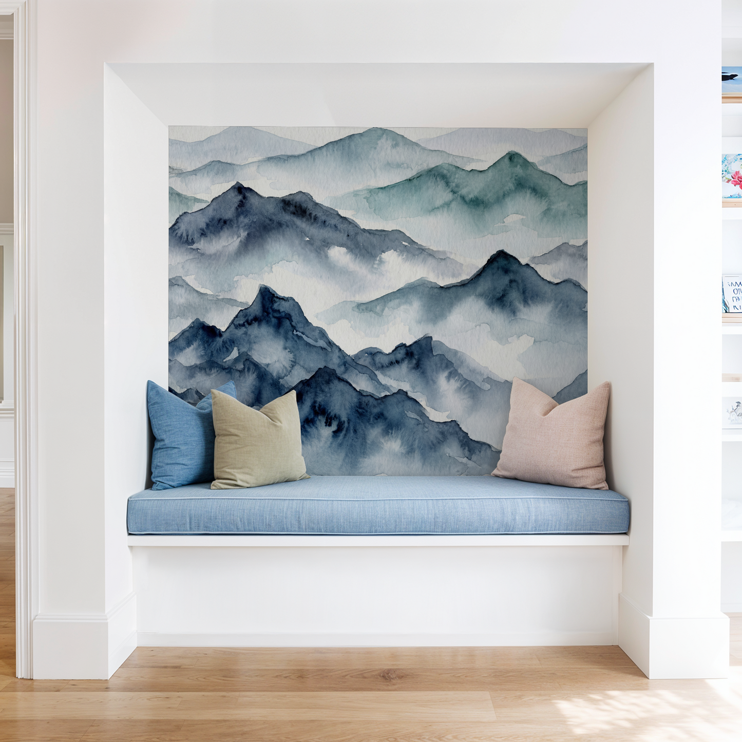 Watercolor mountain wallpaper in a cozy nook with blue and beige cushions.