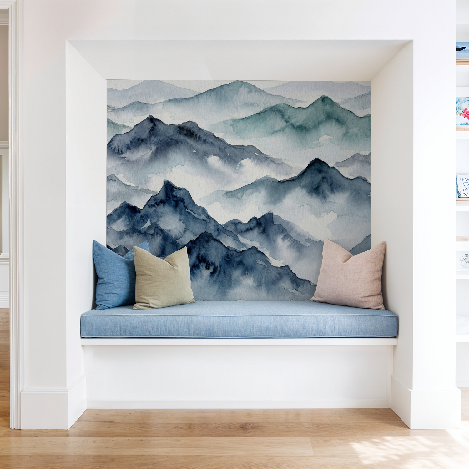 Watercolor mountain wallpaper in a cozy nook with blue and beige cushions.